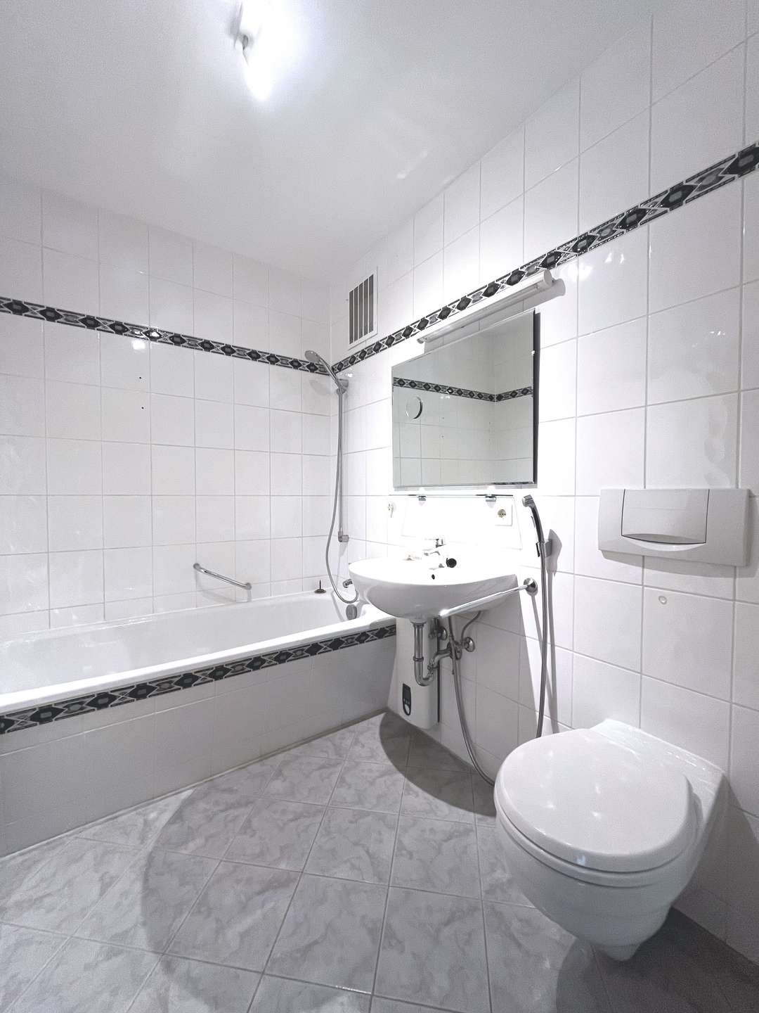 Weißgefliestes Bad mit Wanne