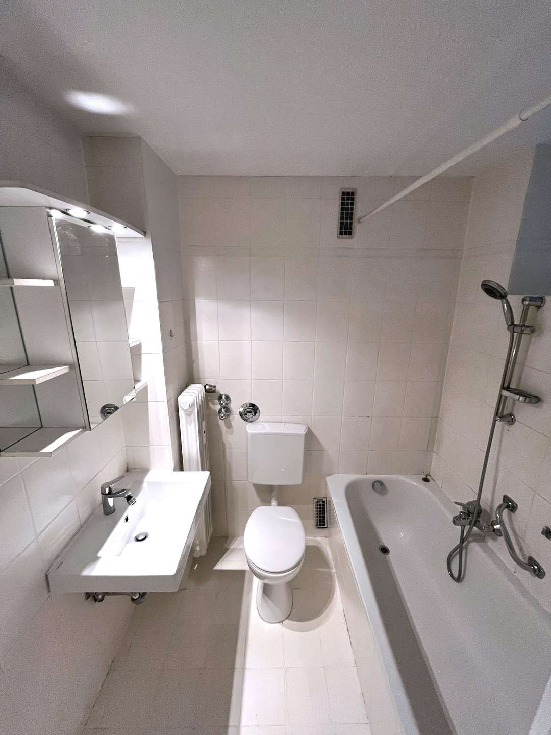 Weiß gefliestes Bad mit Wanne