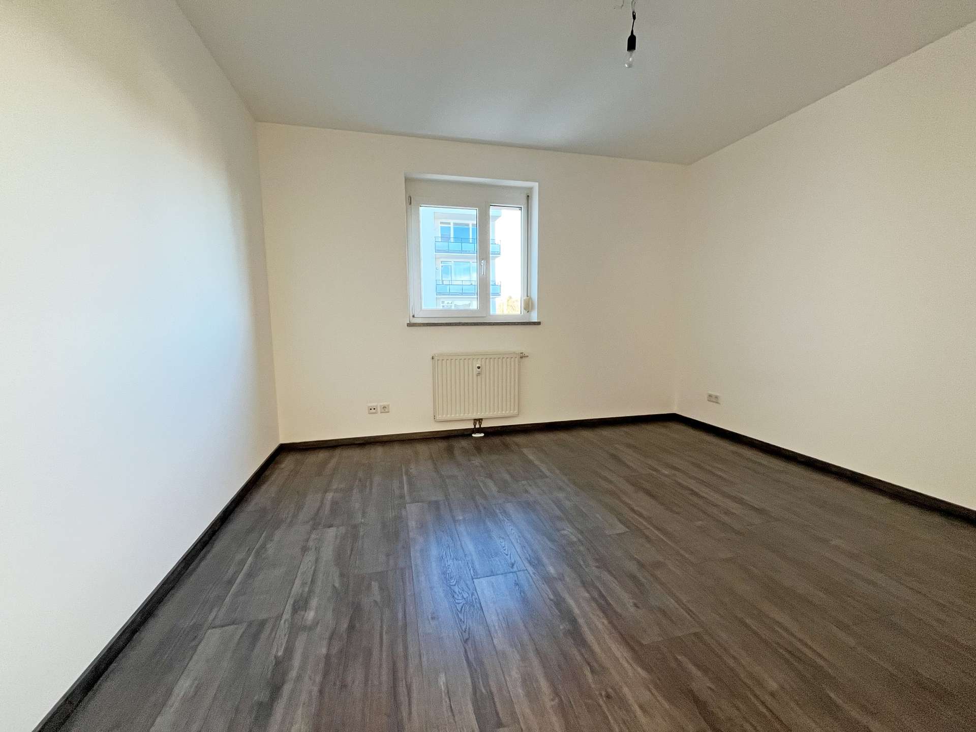 Schlafzimmer mit dunklerem Laminatboden