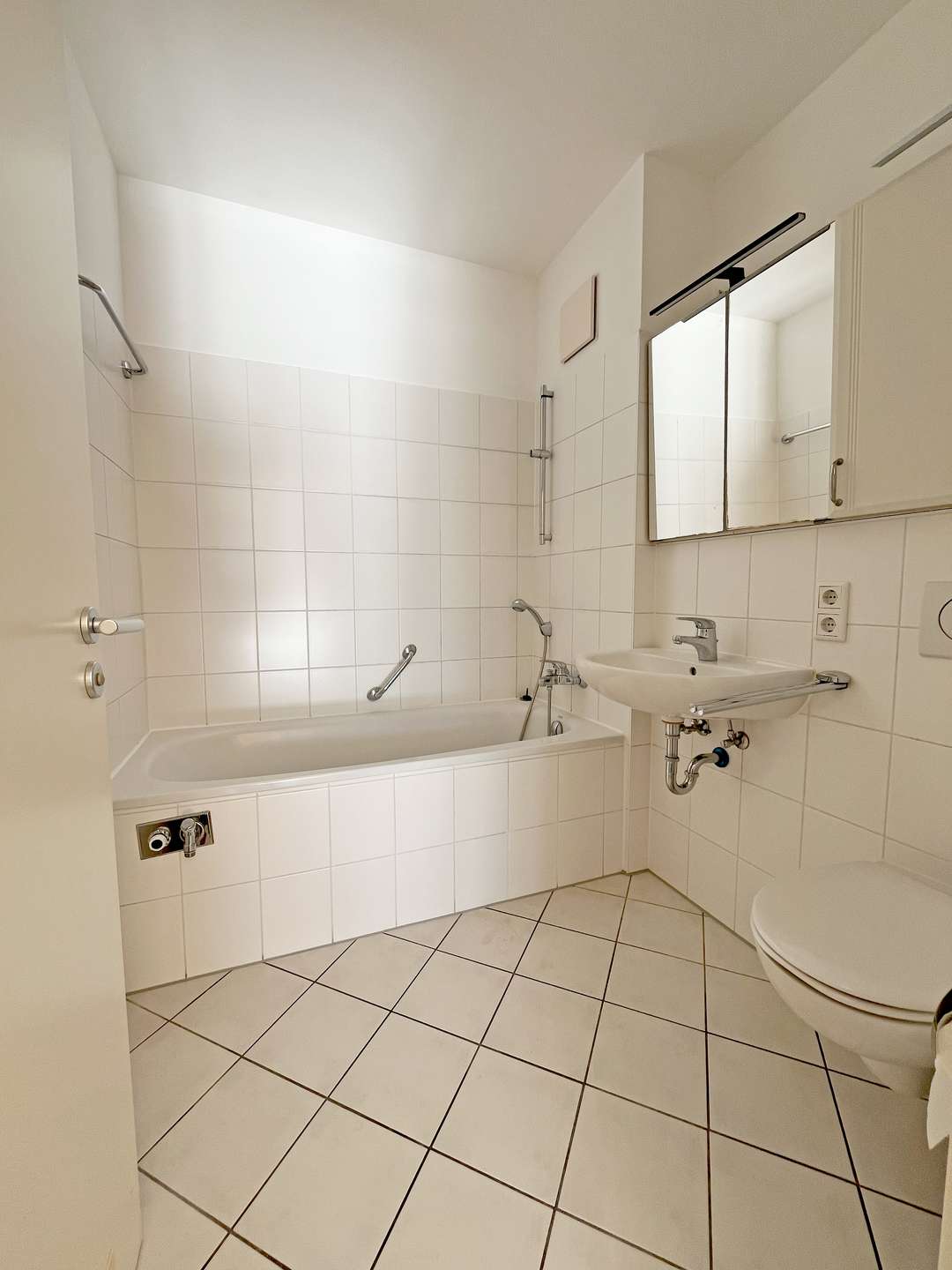 Hell gefliestes Bad mit Wanne