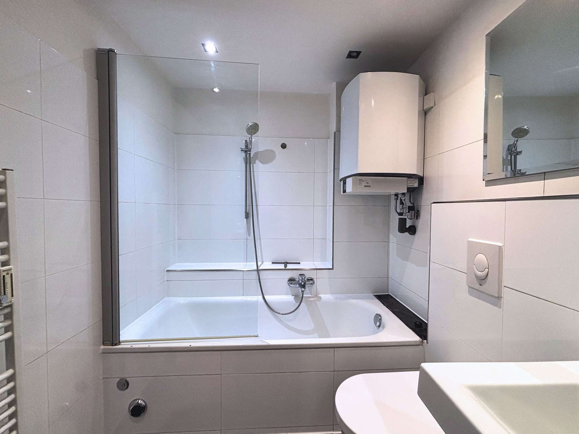 Badezimmer mit Badewanne, Waschbecken und Handtuchheizkörper