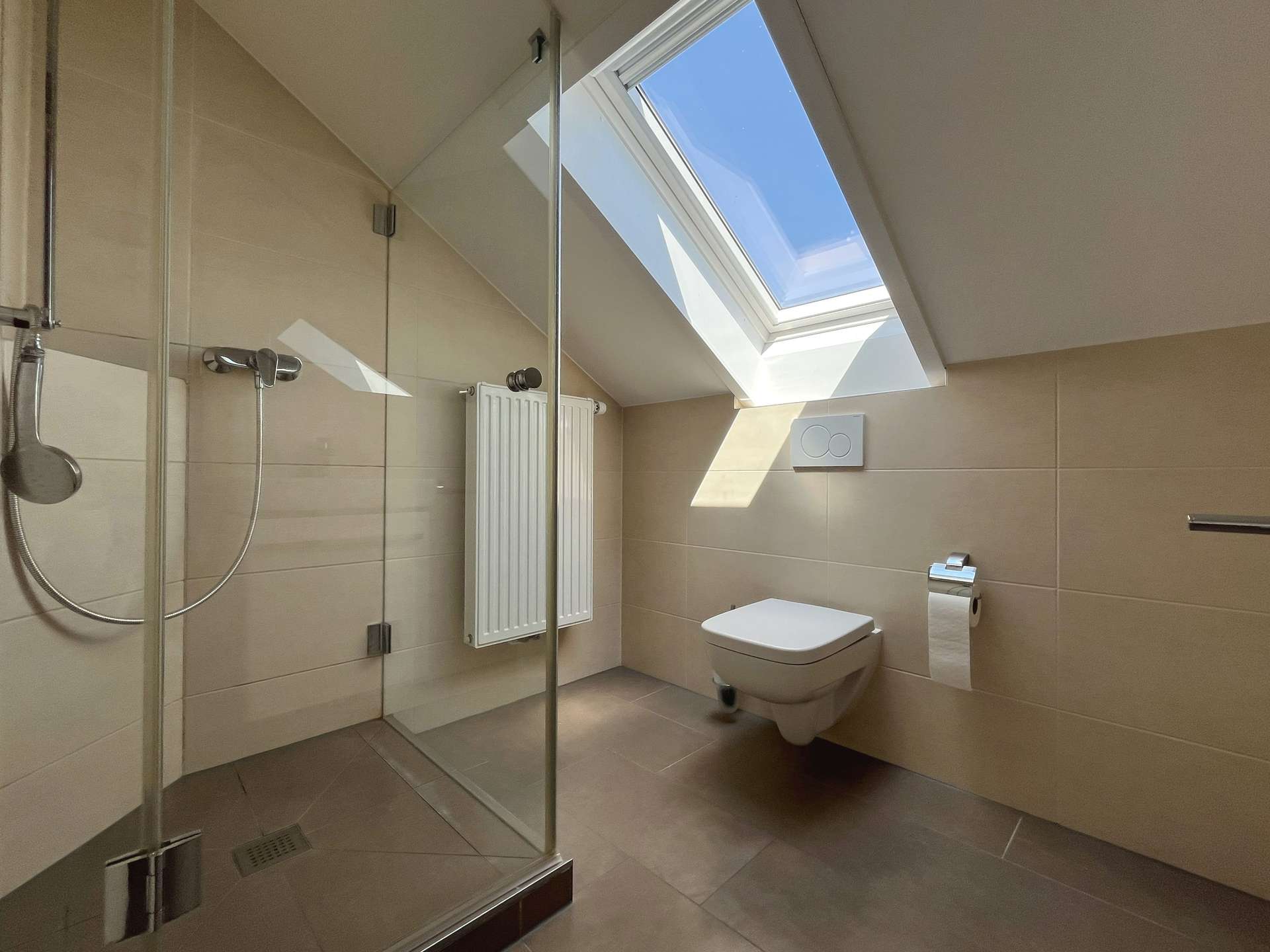 Modernes Duschbad mit Dachfenster und hellen Fliesen