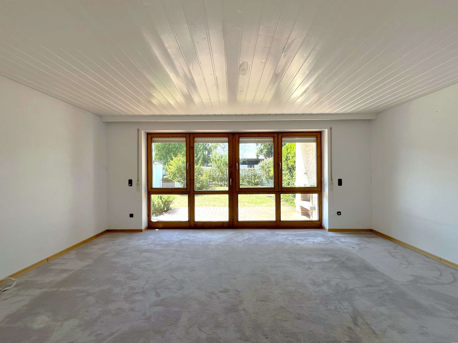 Wohnzimmer mit Fensterfront und Zugang zur Terrasse